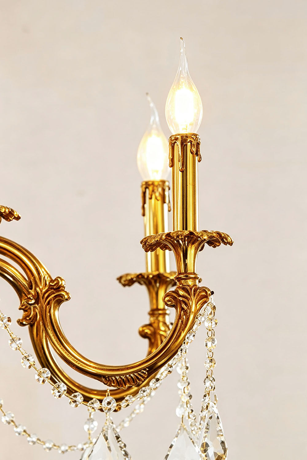 Close-up of the Sidonie Scrolled Brass Crystal Chandelier showing elegant lights and detailed brass accents.