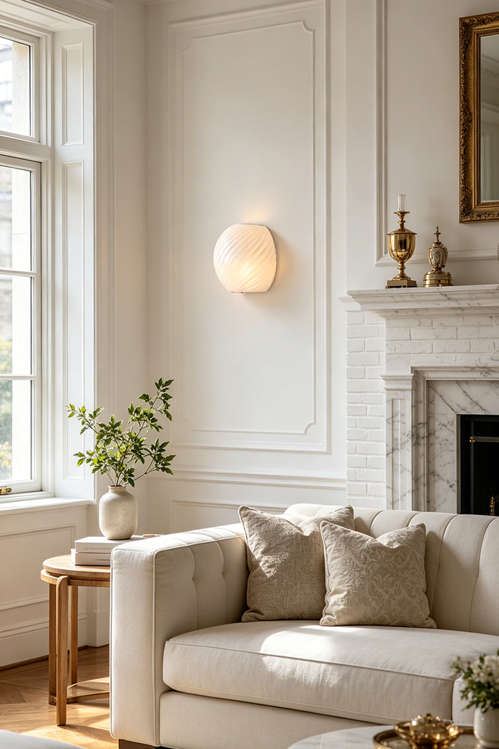 Silas Ribbed Glass Wall Sconce | Ribbed Glass, Metal | White frosted glass variant providing a soft ambient glow on a white paneled wall above a cream sofa in a living room | Samu Lamp
