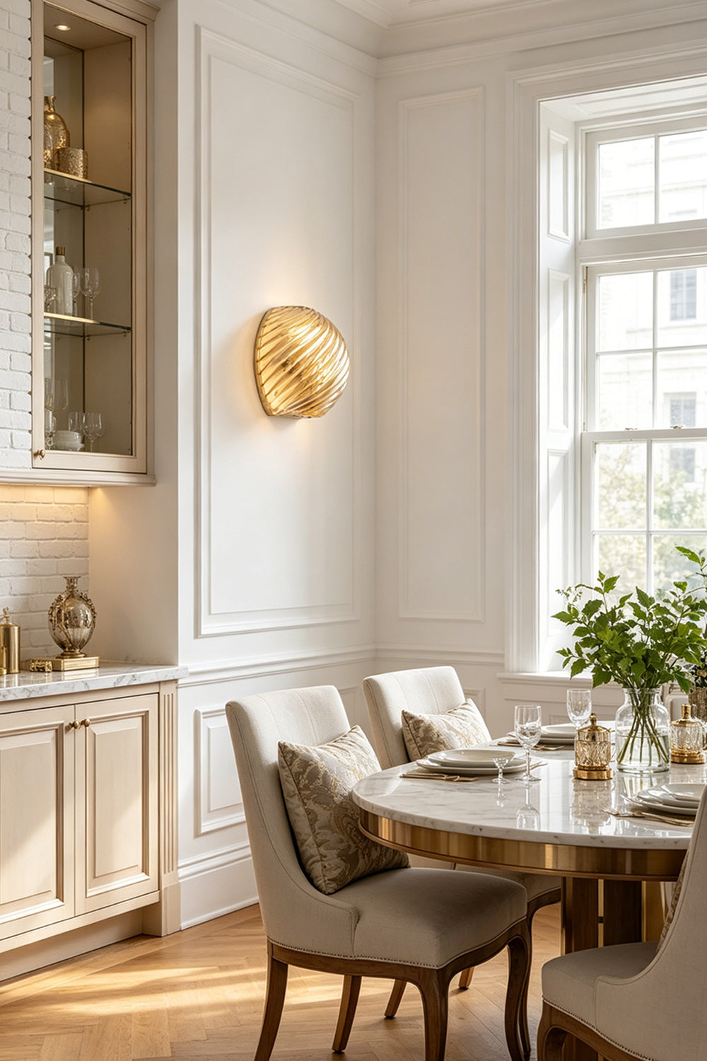 Silas Ribbed Glass Wall Sconce | Ribbed Glass, Metal | Installed as sophisticated ambient lighting in a refined classical dining room casting a warm gold glow next to a table set | Samu Lamp