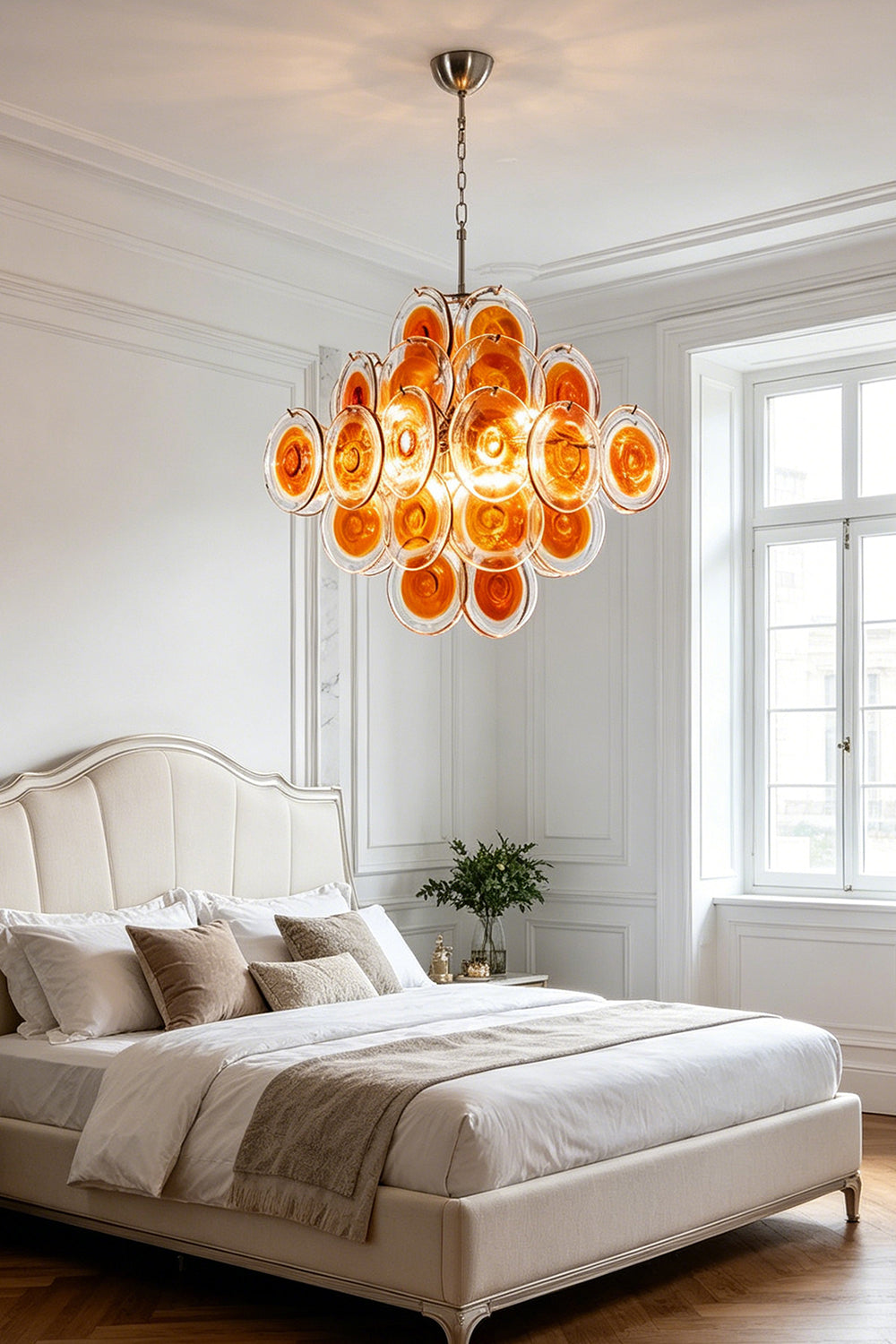Warm-toned amber glass tiered chandelier | Metal, Glass | Installed in a neutral-toned bedroom over a large bed | Samu Lamp