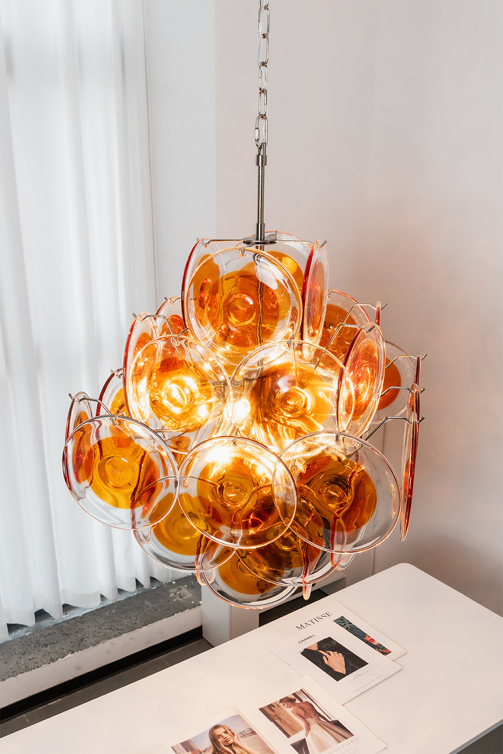 Solari Amber Glass Chandelier | Metal, Glass | High-angle perspective over a desk with open books | Samu Lamp