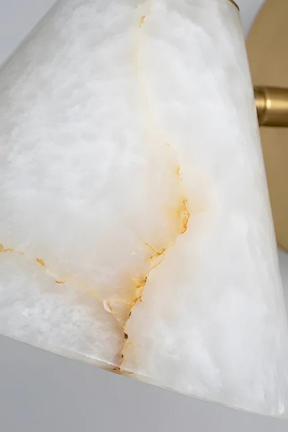 Solene Alabaster Cone Wall Sconce | Alabaster, Brass | Macro close-up focus on the translucent natural white alabaster stone shade highlighting its unique golden mineral veining and crystalline texture | Detail shot | Samu Lamp