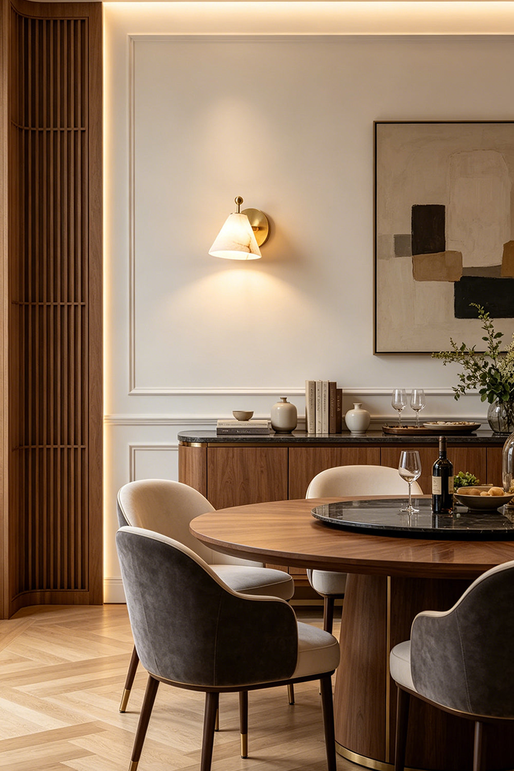 Solene Alabaster Cone Wall Sconce | Alabaster, Brass | Positioned gracefully on a white wall in a refined dining space, providing warm ambient illumination above a round wooden dining table set | Samu Lamp