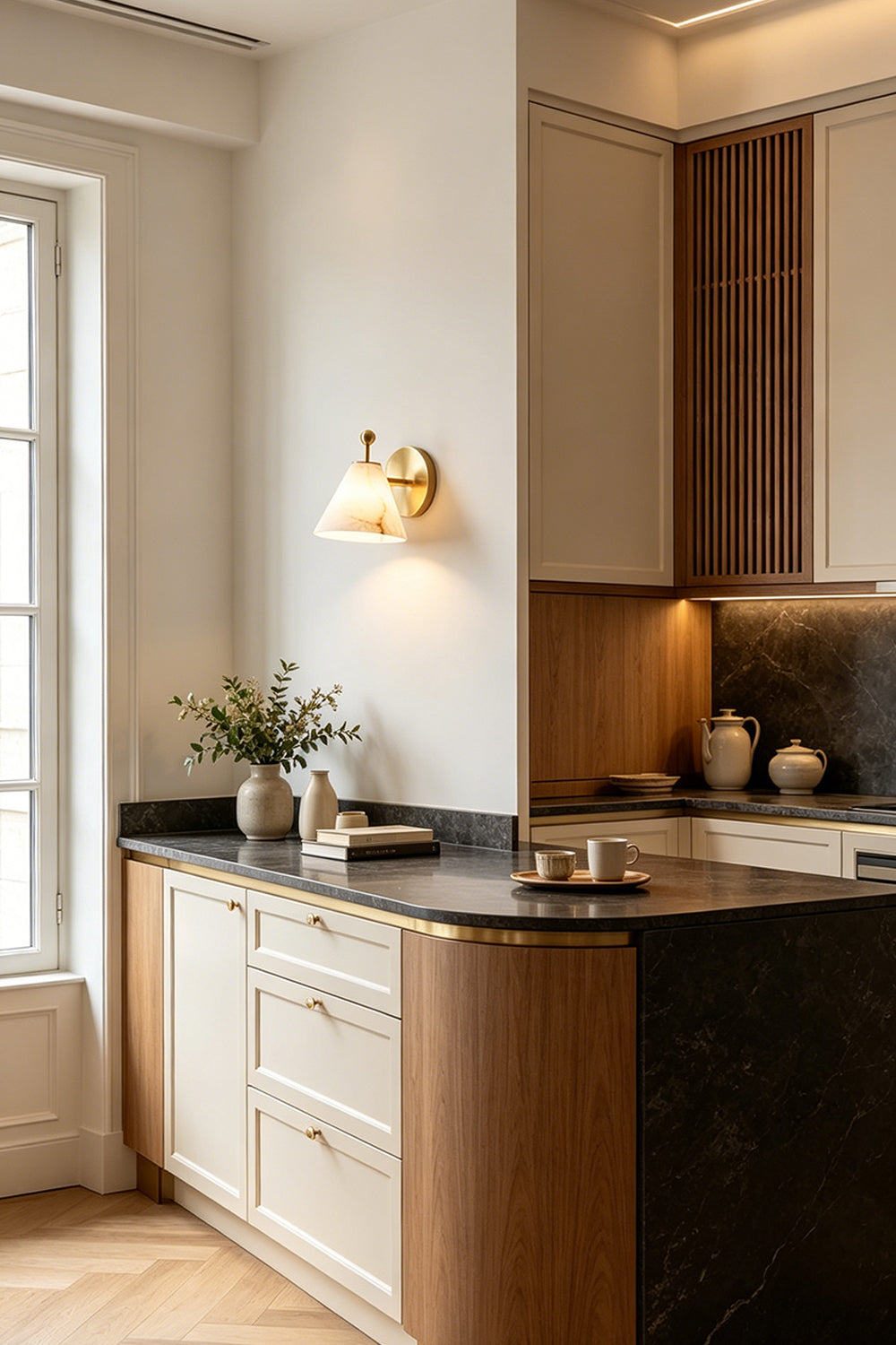 Solene Alabaster Cone Wall Sconce | Alabaster, Brass | Installed as sophisticated accent lighting on a kitchen wall next to modern minimalist wood paneling and cabinetry | Samu Lamp