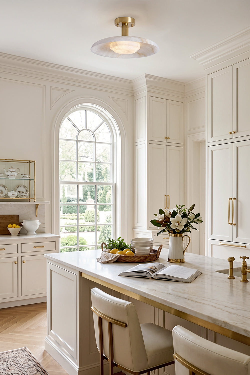 Solene Alabaster Round Ceiling Light | Kitchen Ceiling Fixture | Mounted elegantly in a pristine white classical kitchen space above a marble island counter with matching bar stools | Samu Lamp