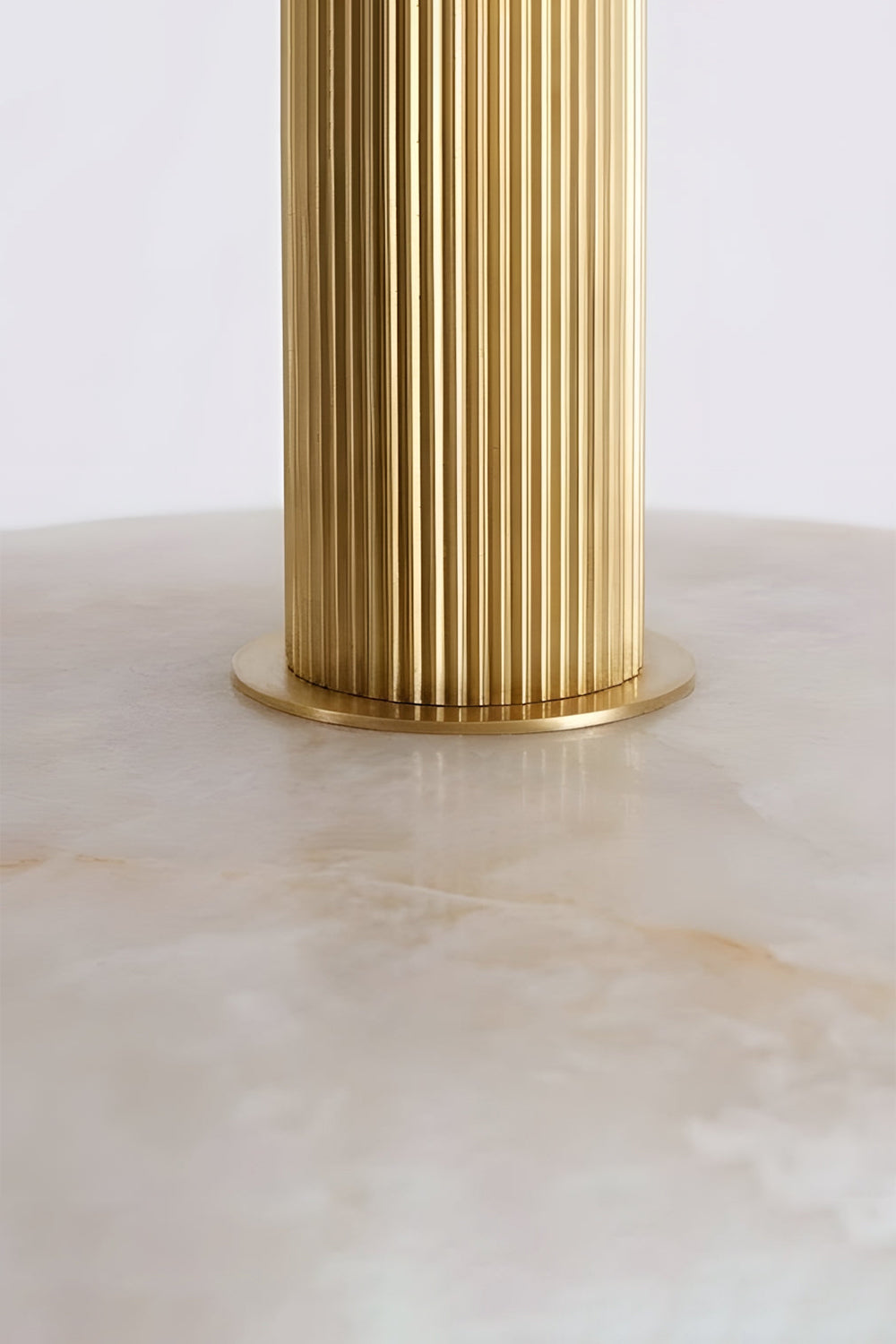 Solene Alabaster Round Ceiling Light | Brass Collar Detail | Detailed macro shot highlighting the ribbed fluted gold brass collar connected to the smooth natural white alabaster stone shade | Detail shot | Samu Lamp