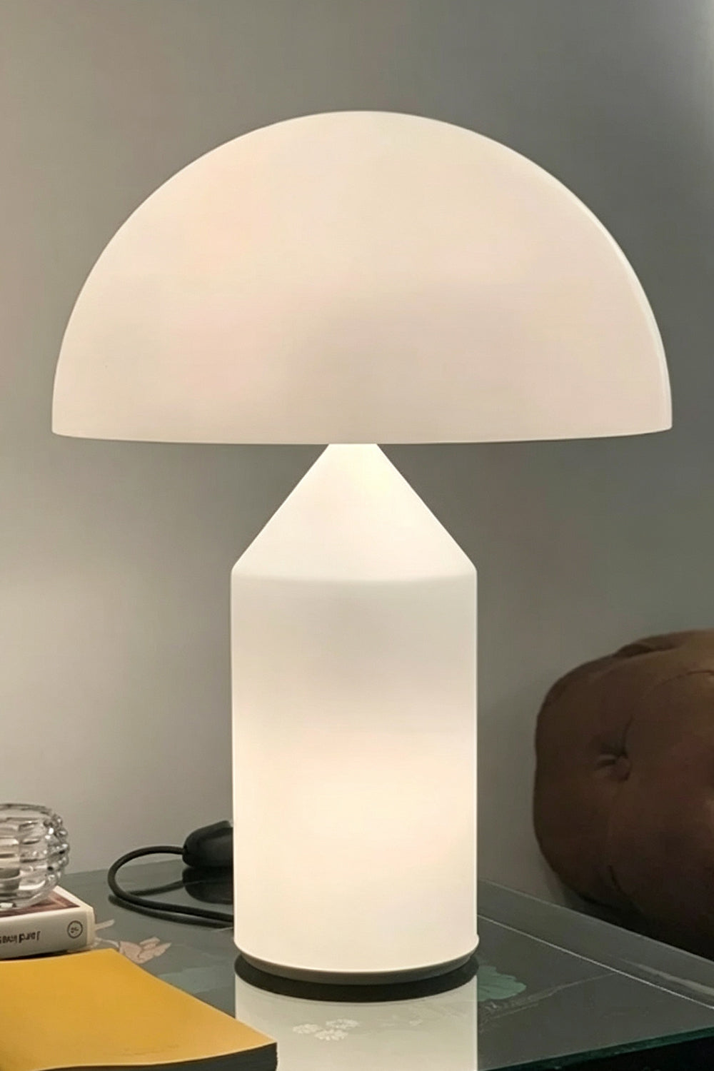 Solene Domed Glass Table Lamp | White Frosted Glass | Close-up shot of the mushroom lamp glowing softly on a dark reflective glass table surface | Samu Lamp