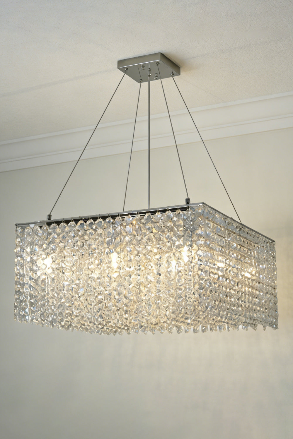 Lit Sparkling Crystal Frame Chandelier against a plain ceiling | Stainless Steel, Crystal | Full front view showing light diffusion | Samu Lamp