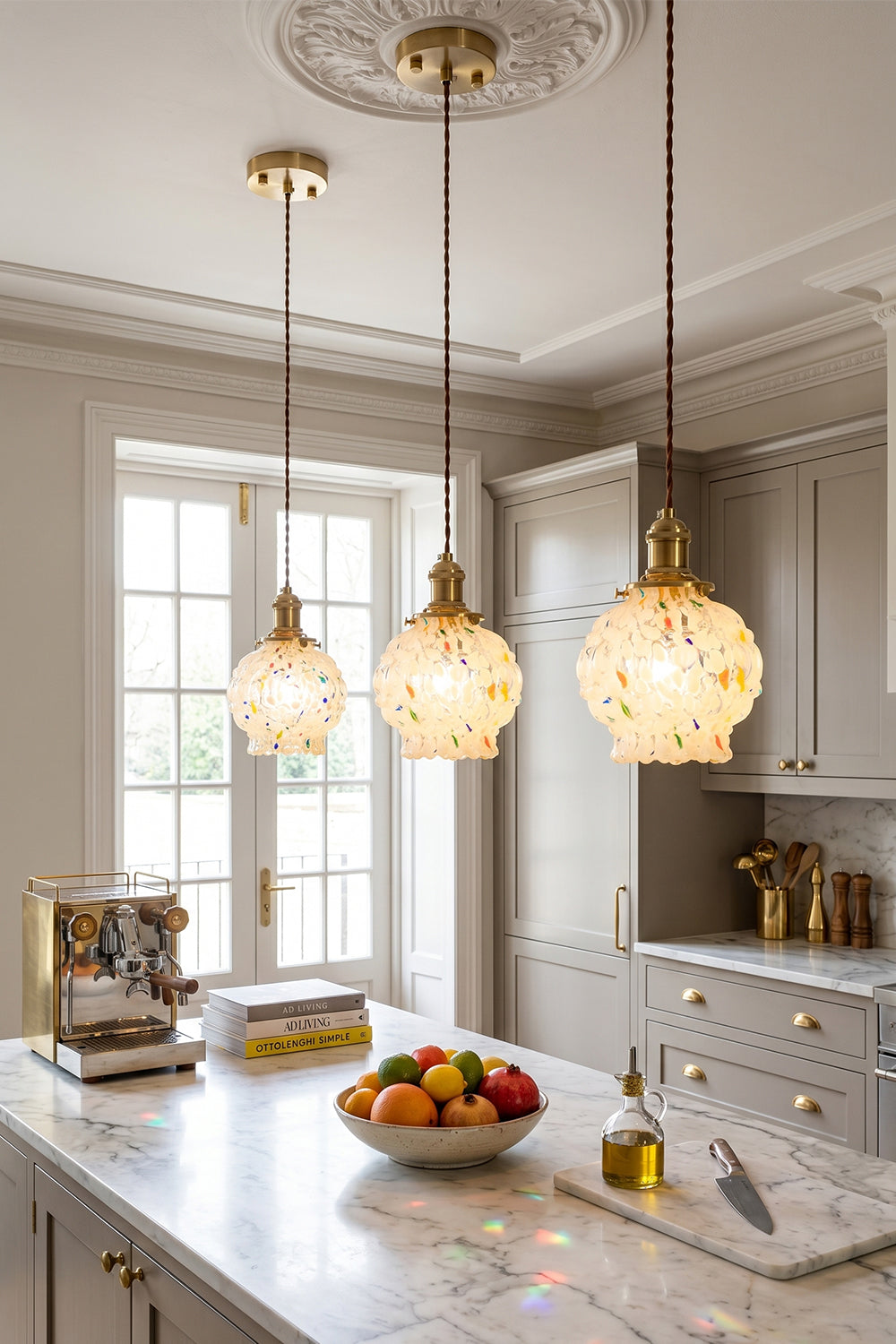 Speckled Bubble Glass Pendant Lamp | Glass, Metal | Three speckled glass pendant lights providing a warm, inviting glow over a clean white marble kitchen counter | Samu Lamp