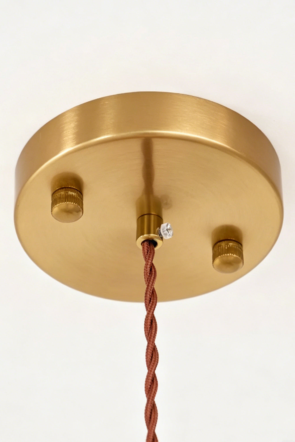 Speckled Bubble Glass Pendant Lamp | Glass, Metal | Close-up view of the circular brushed brass ceiling canopy and a brown twisted fabric electrical cord | Detail shot | Samu Lamp