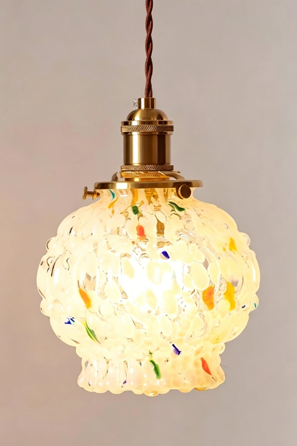 Speckled Bubble Glass Pendant Lamp | Glass, Metal | Detailed shot of the fully illuminated speckled glass shade radiating a warm, textured yellow glow | Samu Lamp