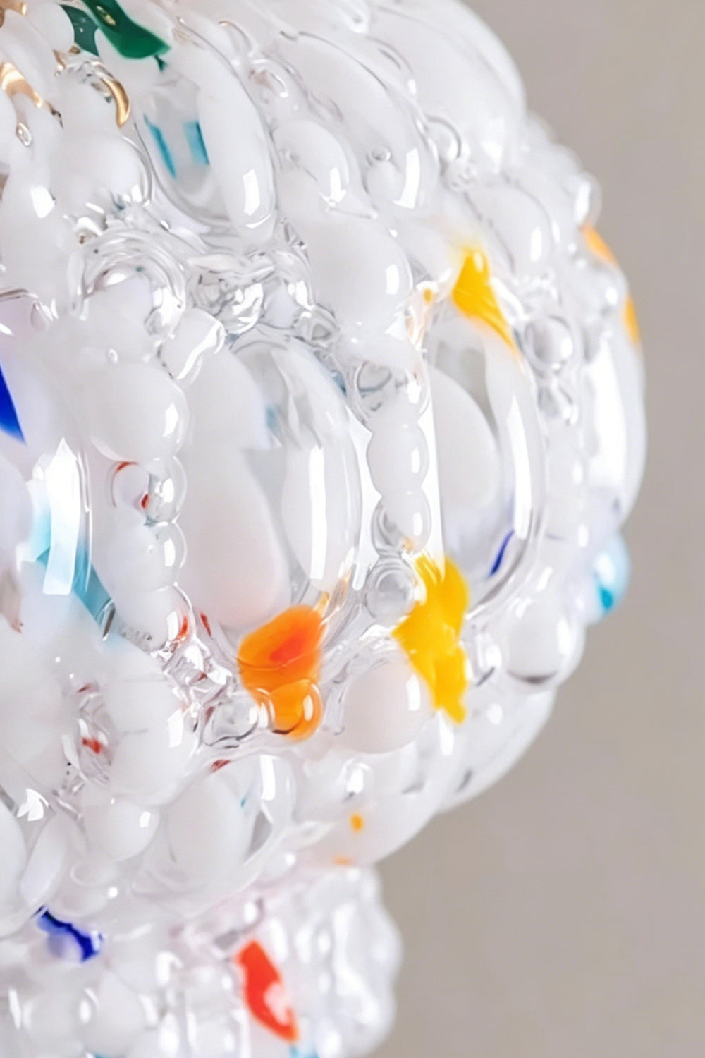 Speckled Bubble Glass Pendant Lamp | Glass, Metal | Macro close-up of the bumpy bubble glass texture embedded with colorful red, orange, and blue glass chips | Detail shot | Samu Lamp