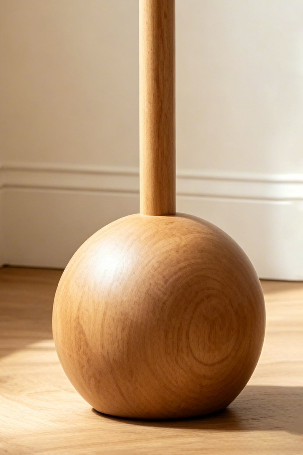 Sphaerica Lignum Wood Floor Lamp | Metal, Wood, Fabric | Close-up detail of the spherical solid wood base and smooth vertical stem on a wooden floor | Samu Lamp