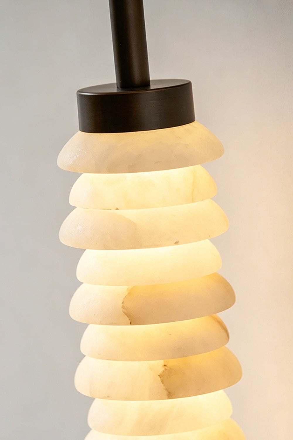 Stacked Strata Alabaster Wall Lamp | Metal, Alabaster | Lit lamp near dark modern kitchen cabinets | Samu Lamp