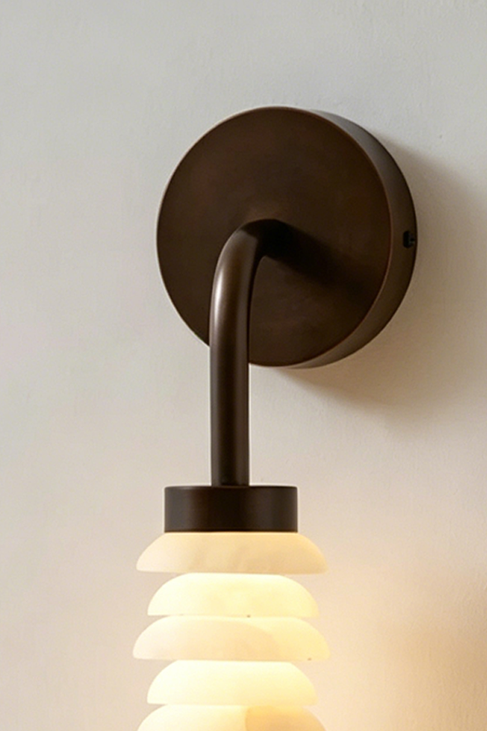 Stacked Strata Alabaster Wall Lamp | Alabaster, Metal | Close-up view of lit lamp on grey wall near console | Samu Lamp