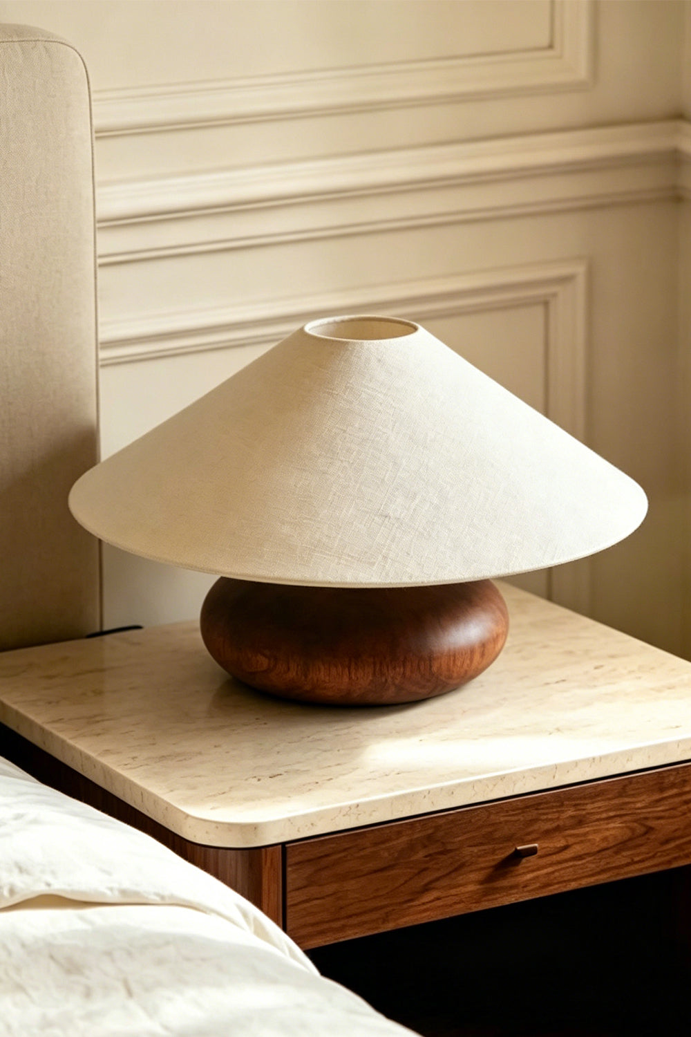 Sylvan Oval Walnut Table Lamp | Wood, Fabric, Metal | Placed on a marble-top wooden nightstand next to a bed with white sheets | Samu Lamp