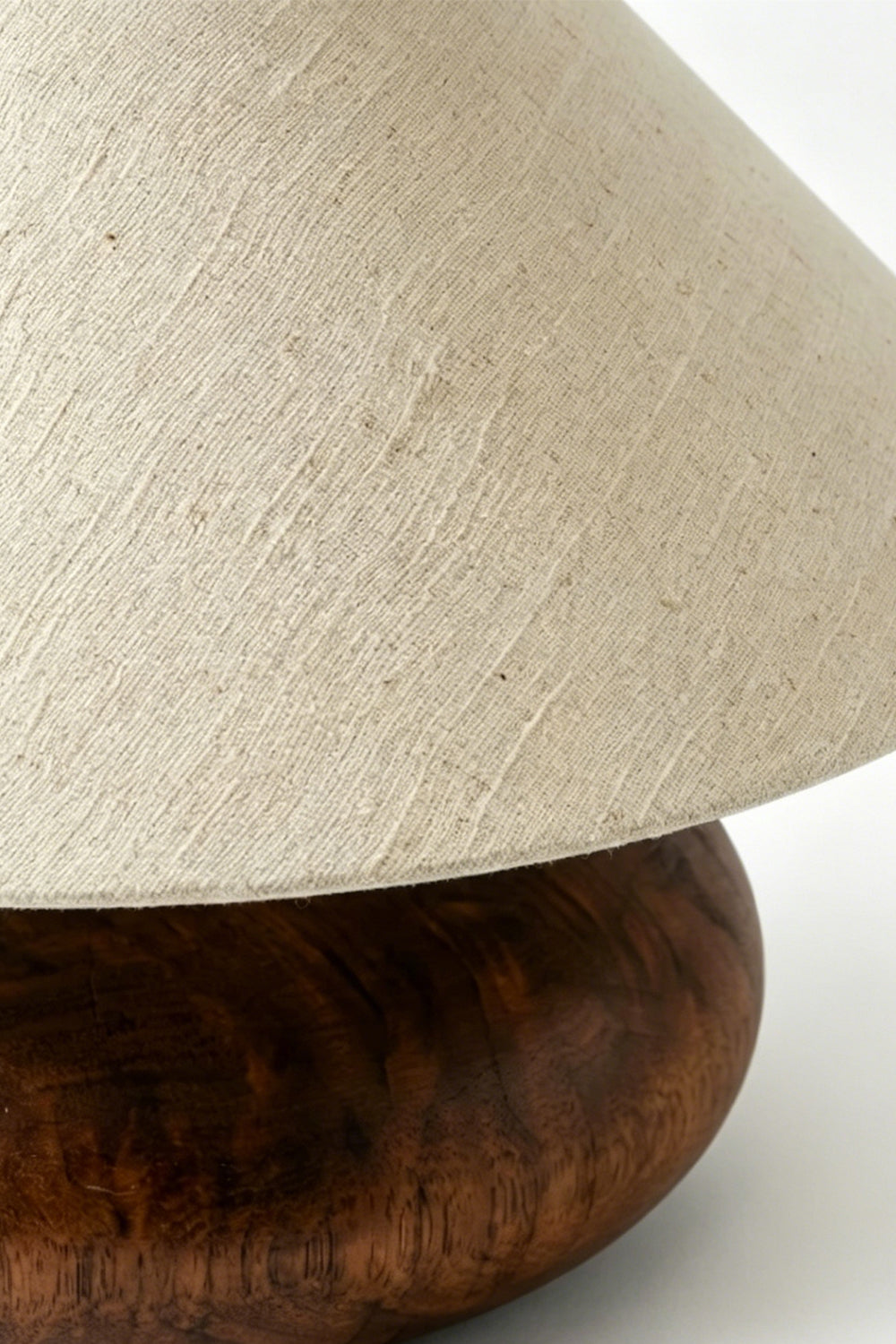 Sylvan Oval Walnut Table Lamp | Wood, Fabric, Metal | Close-up side view showcasing the sleek interface between the fabric shade and walnut wood base | Detail shot | Samu Lamp Sylvan Oval