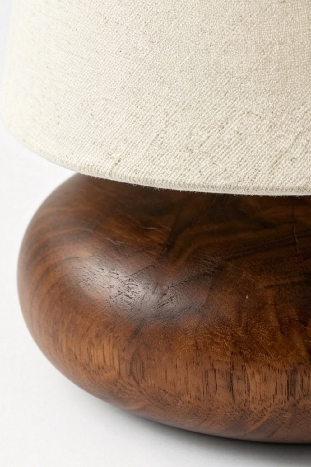 Sylvan Oval Walnut Table Lamp | Wood, Fabric, Metal | Macro view emphasizing the organic texture of the beige fabric and the rich grain of the walnut base | Detail shot | Samu Lamp Sylvan Oval