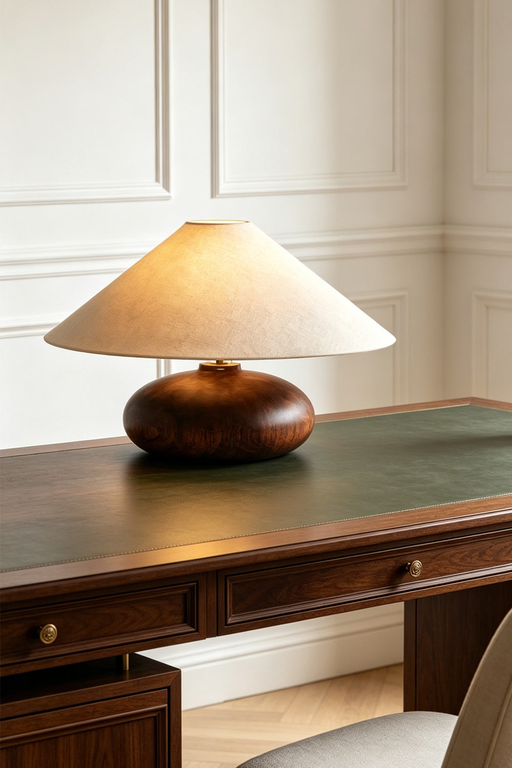 Sylvan Oval Walnut Table Lamp | Wood, Fabric, Metal | Placed on a classic dark wood desk with a green leather top against a white paneled wall | Samu Lamp