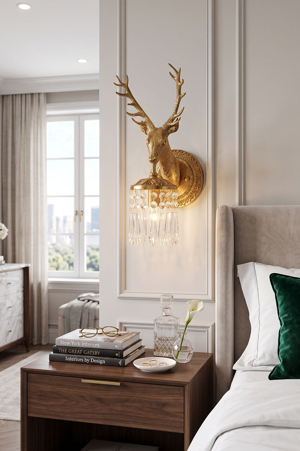 Sylvestre Cast Brass Stag Wall Sconce illuminating a stylish bedroom beside a wooden nightstand.
