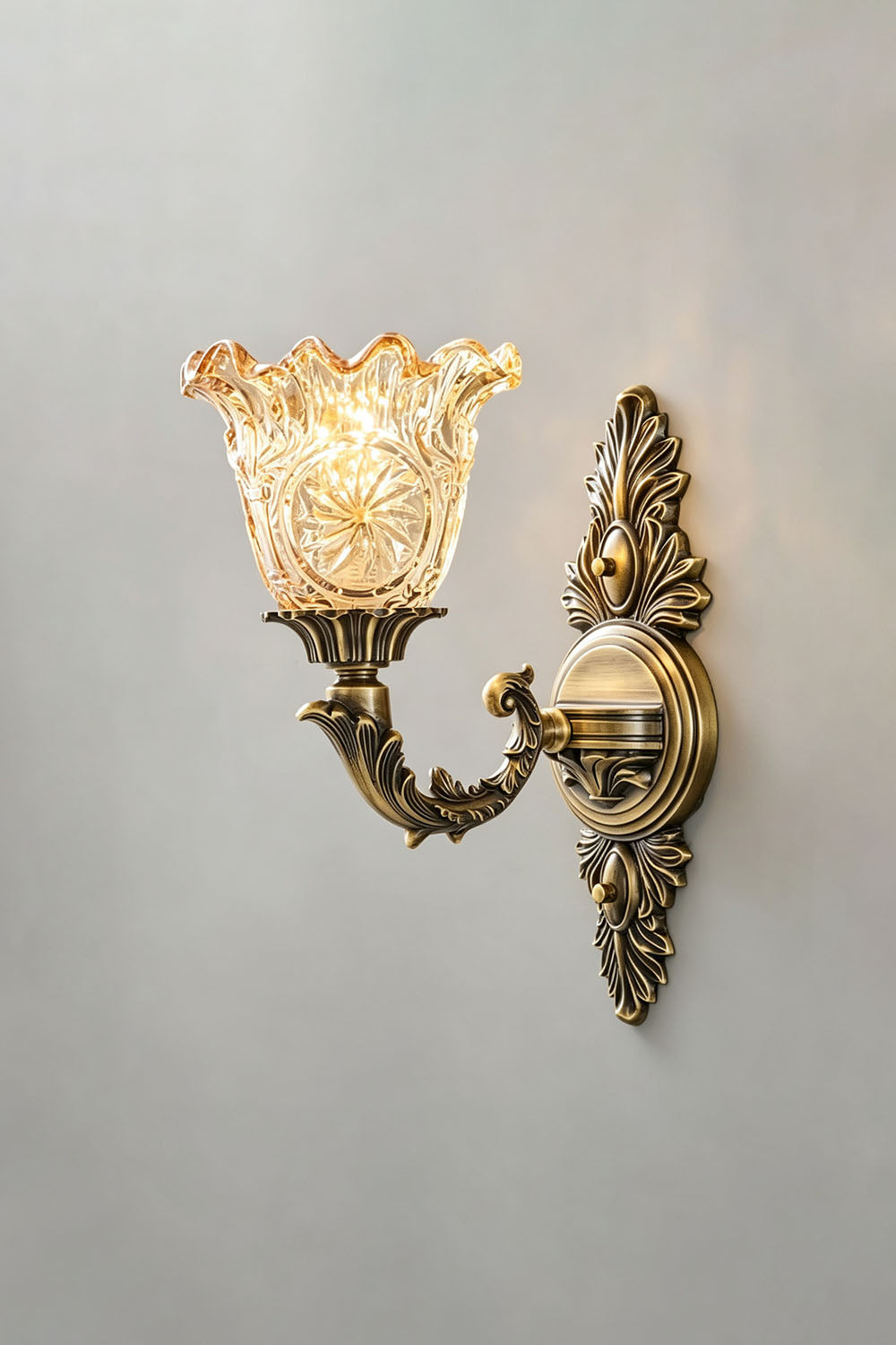 Sylvestre Petal Glass Brass Wall Lamp elegantly displaying a vintage design with a decorative glass shade.