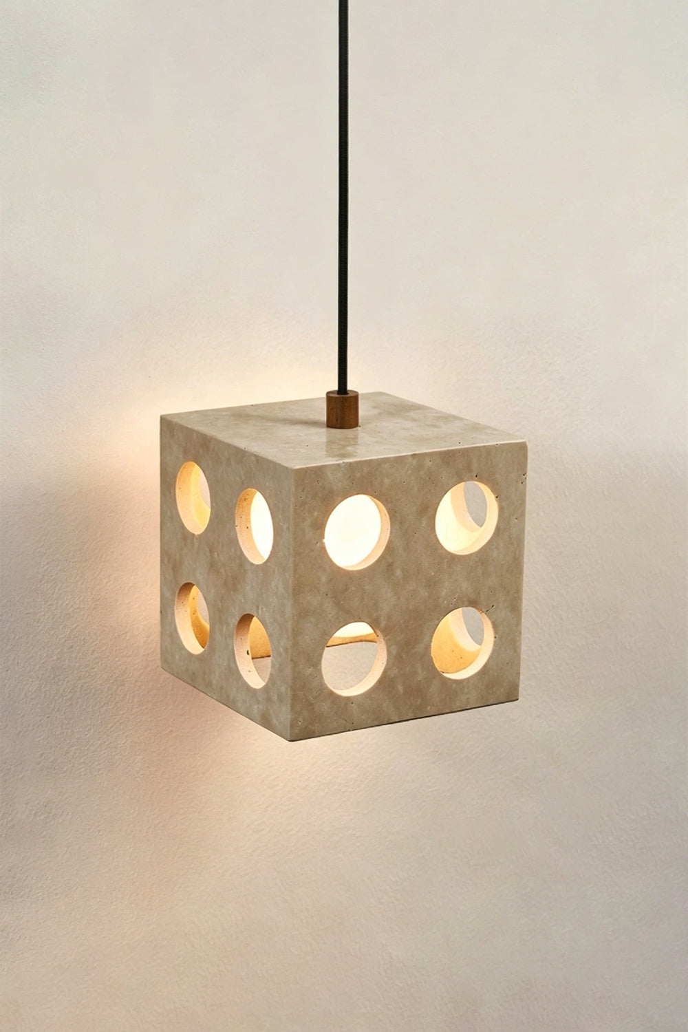 Terra Cube Travertine Pendant Light | Travertine, Metal | Lit product view showing light patterns against a wall | Samu Lamp