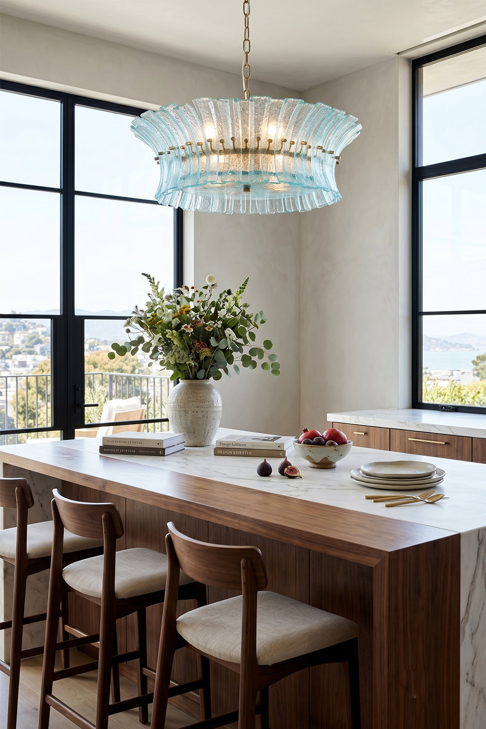 Thalassa Aquamarine Textured Glass Chandelier | Glass, Metal | Suspended gracefully above a long wooden dining table set with modern chairs in a spacious room with floor-to-ceiling windows | Samu Lamp
