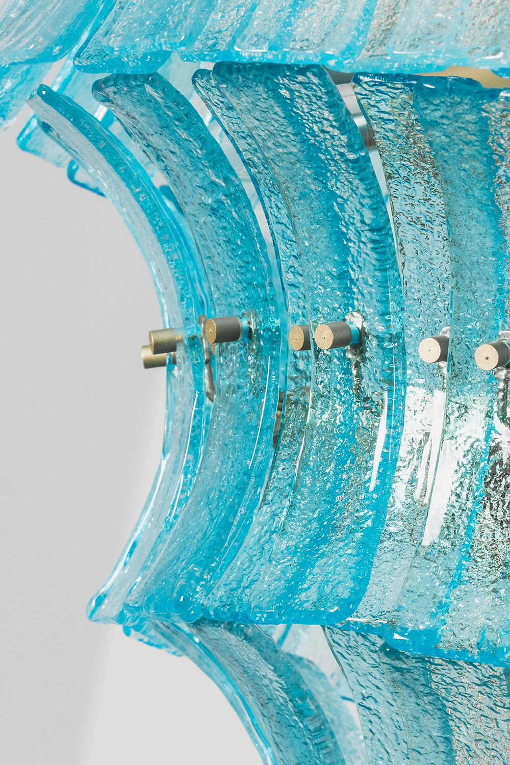 Thalassa Aquamarine Textured Glass Chandelier | Glass, Metal | Close-up side profile highlighting the wave-like rippled edges of the blue glass tiles and the gold frame attachments | Detail shot | Samu Lamp