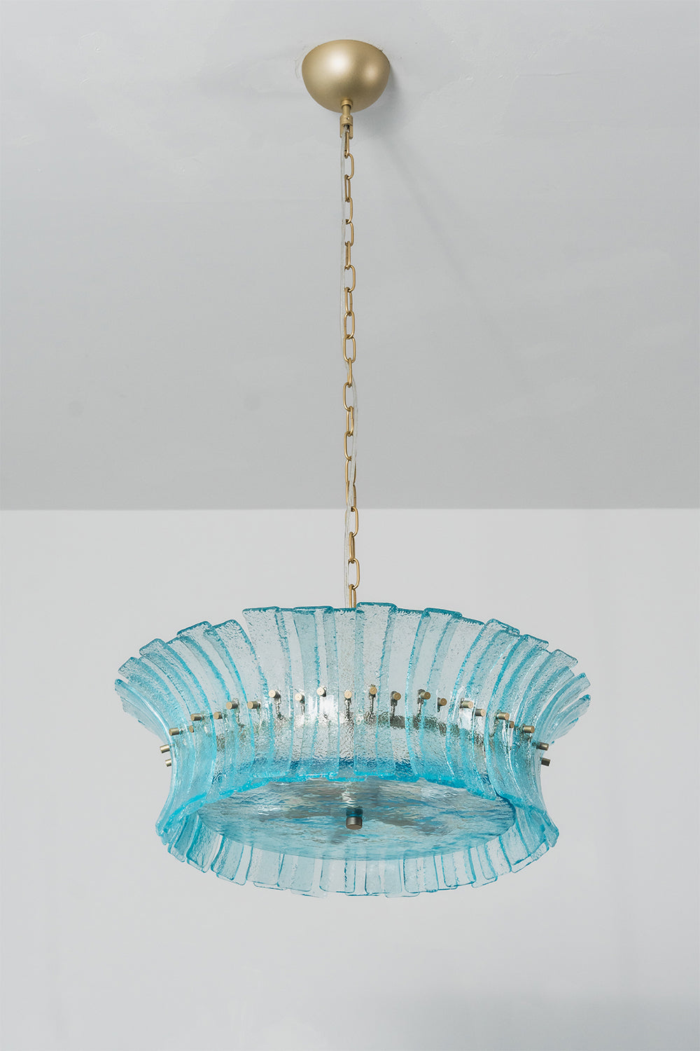 Thalassa Aquamarine Textured Glass Chandelier | Glass, Metal | Studio variant view of a shallower wide-rimmed tier version of the blue glass chandelier illuminated against a plain background | Samu Lamp