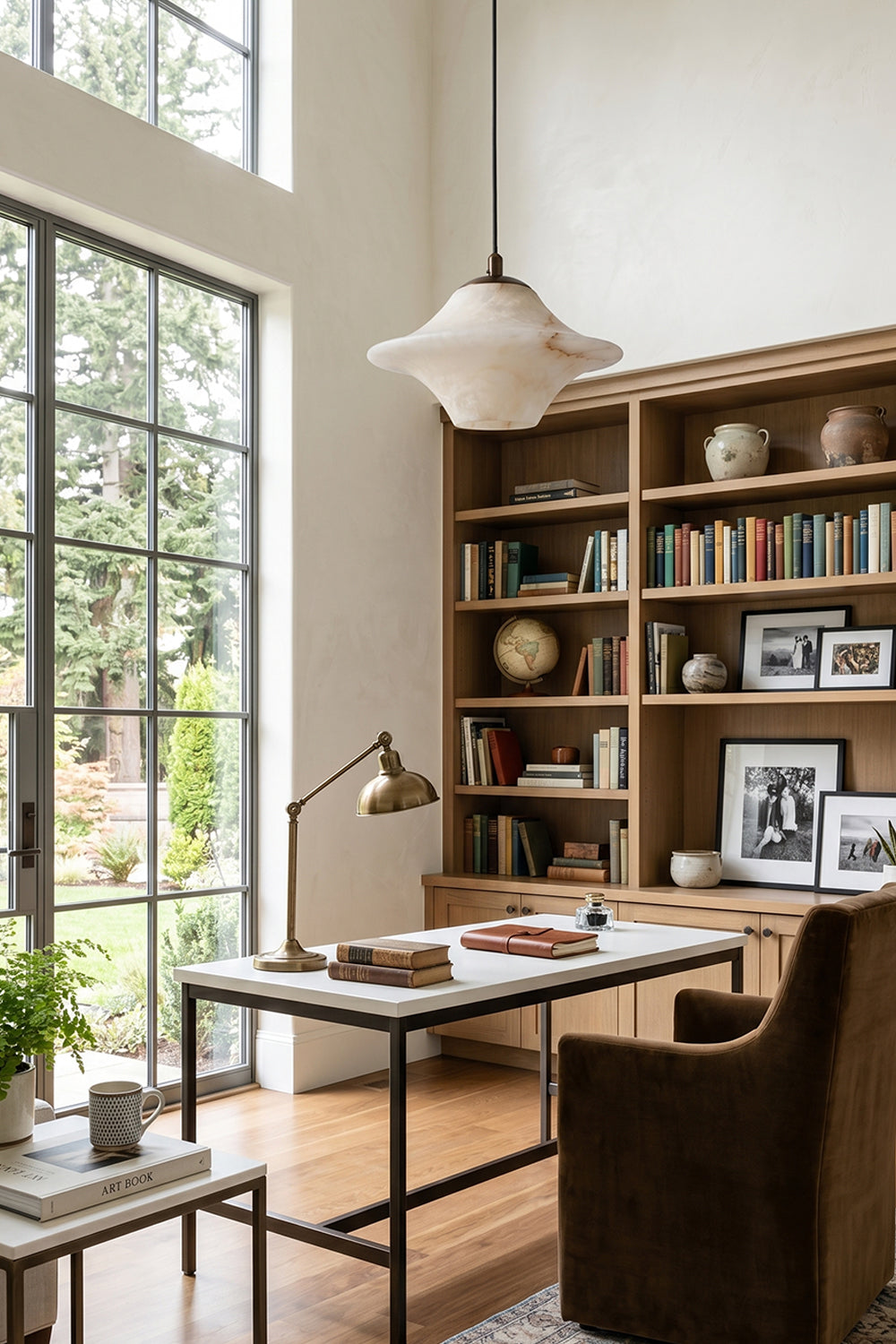 Thalia Alabaster Flared Pendant Light | Alabaster, Metal | Suspended gracefully as overhead lighting in a high-ceilinged home study room featuring an industrial desk, large windows, and library shelves | Samu Lamp