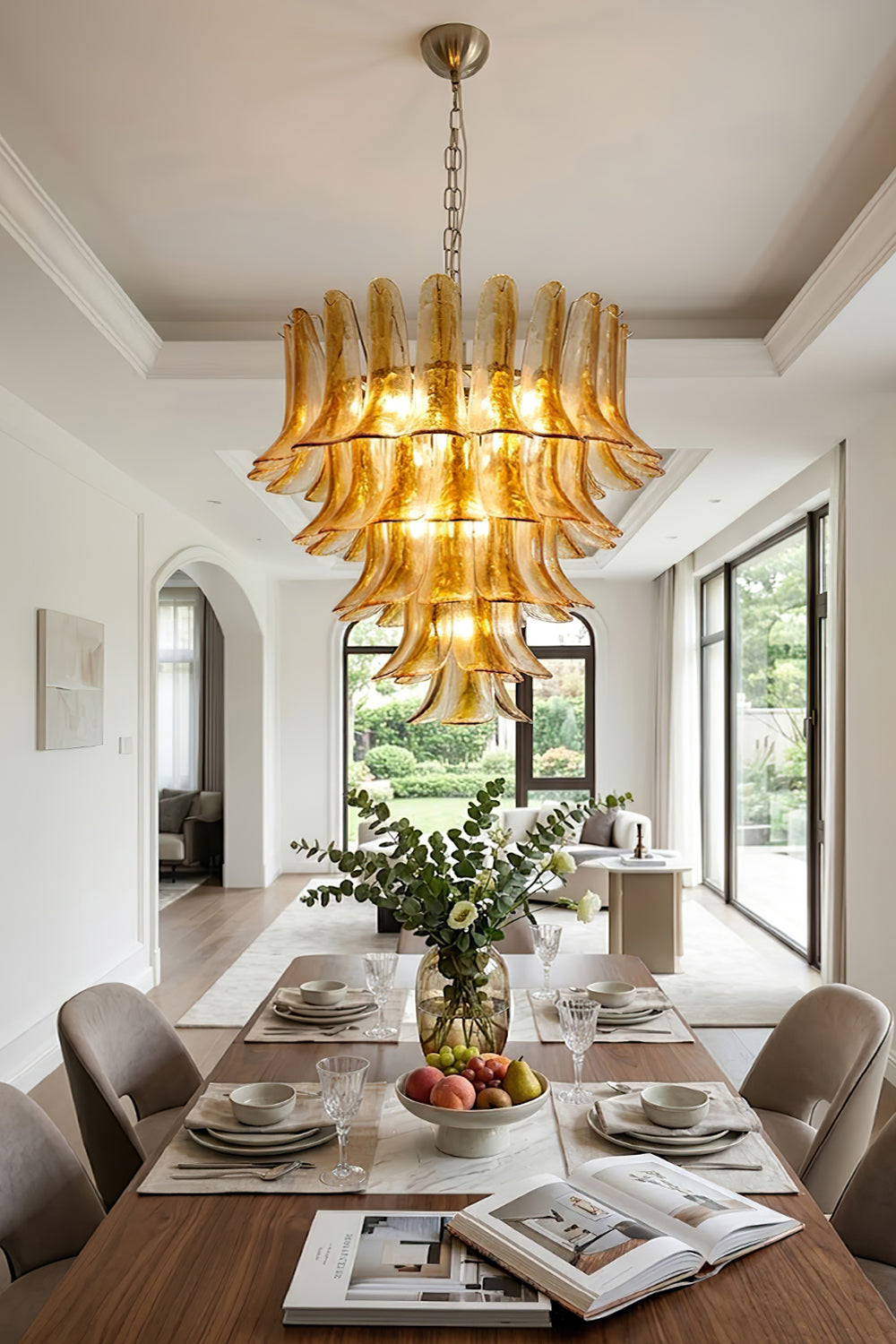 Lit amber lily glass chandelier over dining set | Metal, Glass | Traditional dining room interior with magazines and plants | Samu Lamp