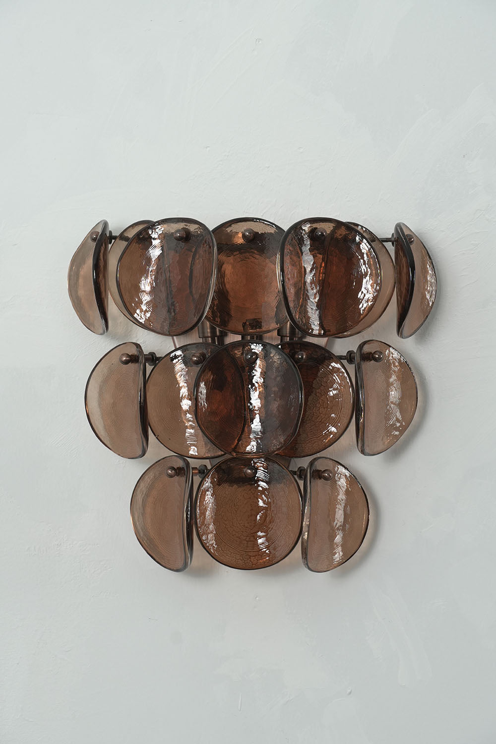 Tisanne Tiered Glass Disc Wall Lamp | Smoked Glass and Metal | Direct front product view unlit displayed on a plain light wall | Samu Lamp