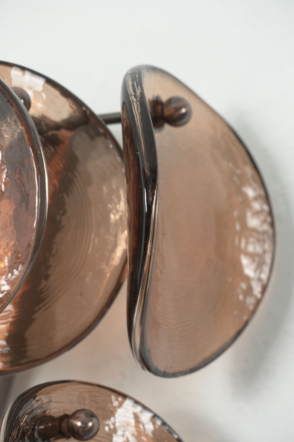 Tisanne Tiered Glass Disc Wall Lamp | Smoked Glass and Metal | Angled side detail of curved smoked glass discs and metal mounting brackets | Samu Lamp