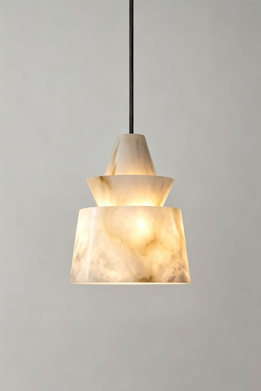 Tobiah Tiered Alabaster Pendant Light | Natural Alabaster and Metal | Full view of the pendant light displayed gracefully on a plain grey wall | Samu Lamp