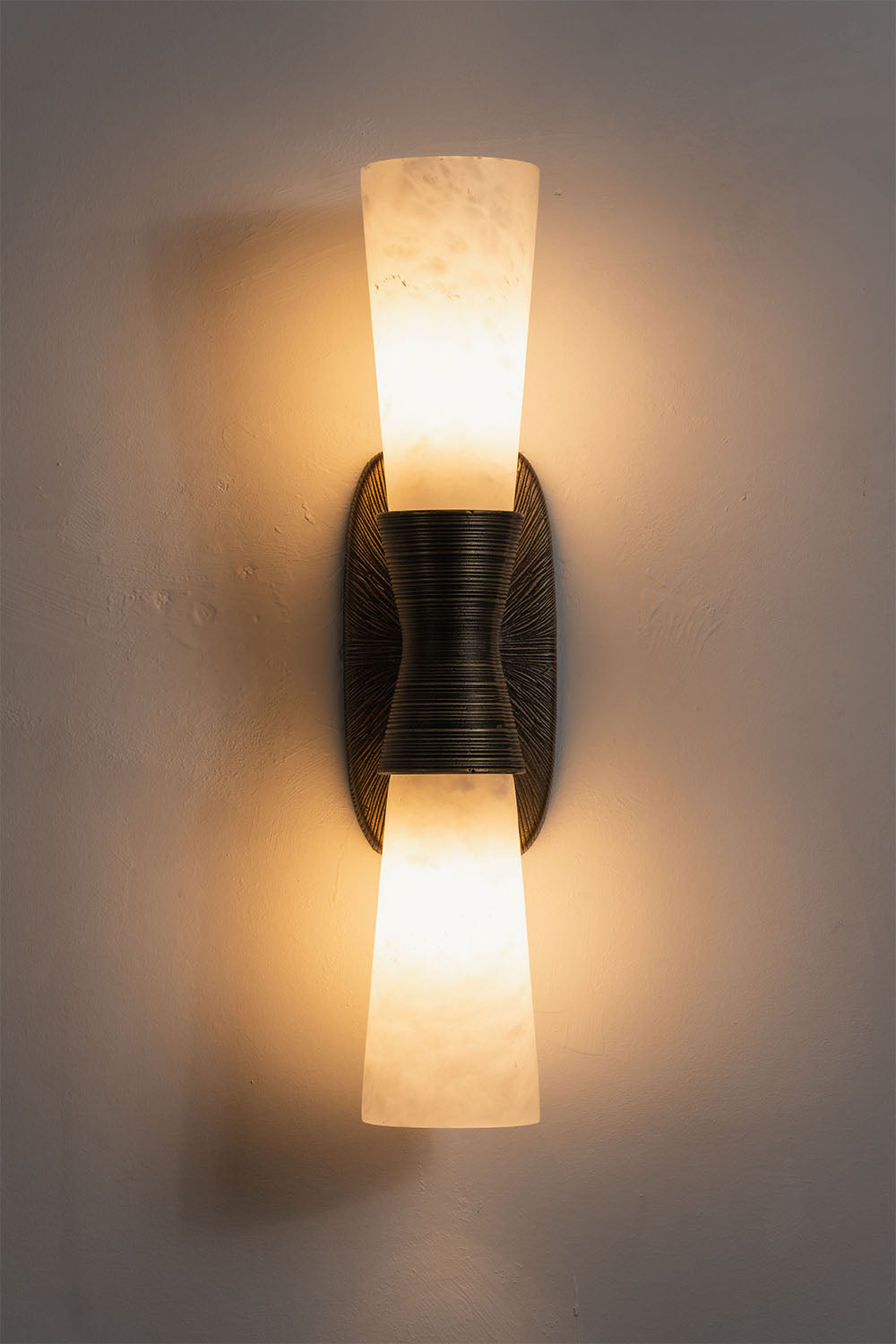 Torsanne Wall Sconce | Alabaster and Bronze | Two-light model illuminated front view on grey wall | Samu Lamp