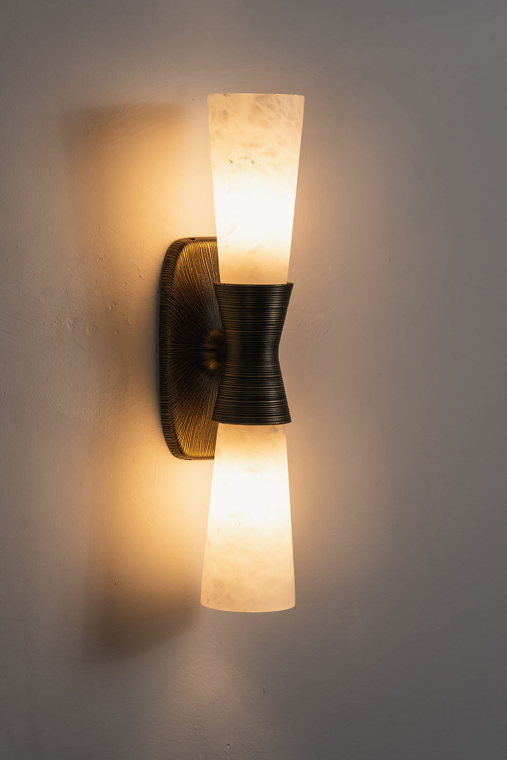 Torsanne Wall Sconce | Alabaster and Bronze | Two-light model lit at an angle casting warm wall glow | Samu Lamp