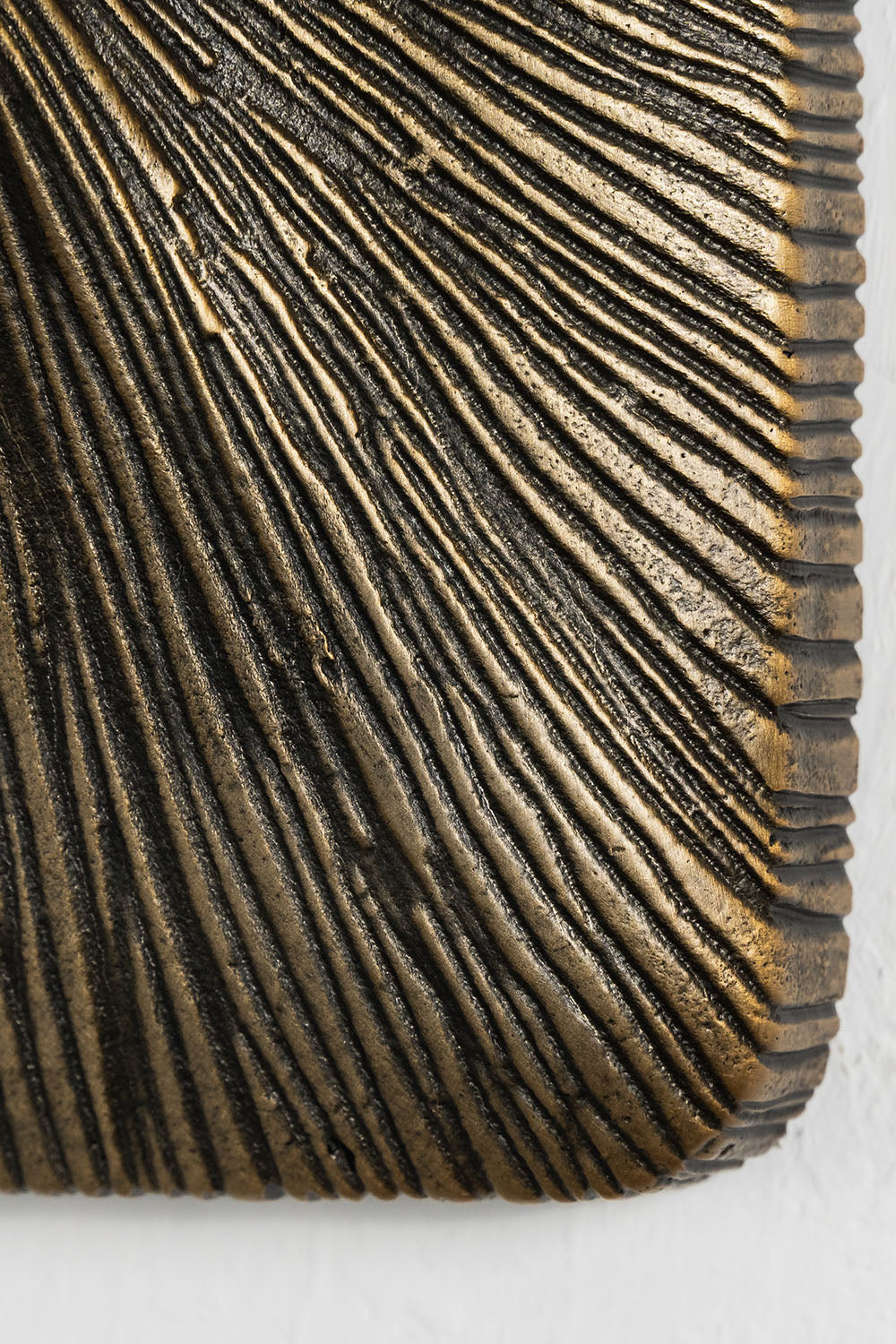 Torsanne Wall Sconce | Textured Cast Bronze | Macro detail of striated linear texture on wall plate | Samu Lamp