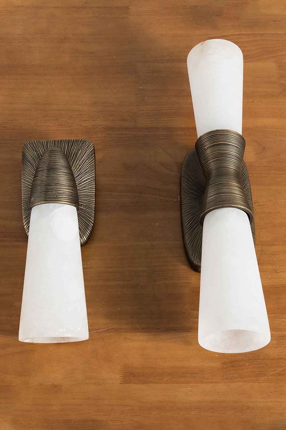 Torsanne Wall Sconce | Alabaster and Bronze | 1-light and 2-light variants laid flat on wooden table | Samu Lamp