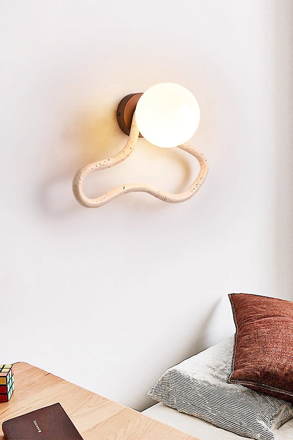 Lit travertine flow wall light in a modern bedroom | Travertine, Glass, Wood | Mounted above a desk near the bed | Samu Lamp