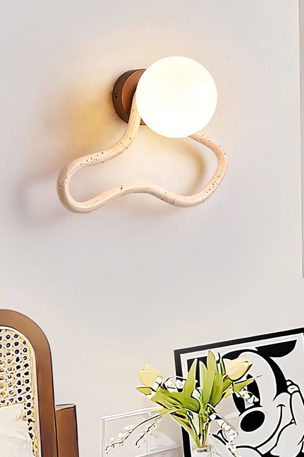 Lit travertine flow sconce on a white wall | Travertine, Glass, Wood | Detailed view of the wavy stone and glass globe | Samu Lamp
