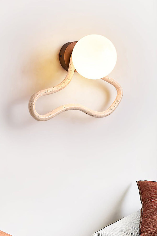 Warm glow from a travertine flow wall lamp | Travertine, Glass, Wood | Close-up showing the organic travertine loop | Samu Lamp