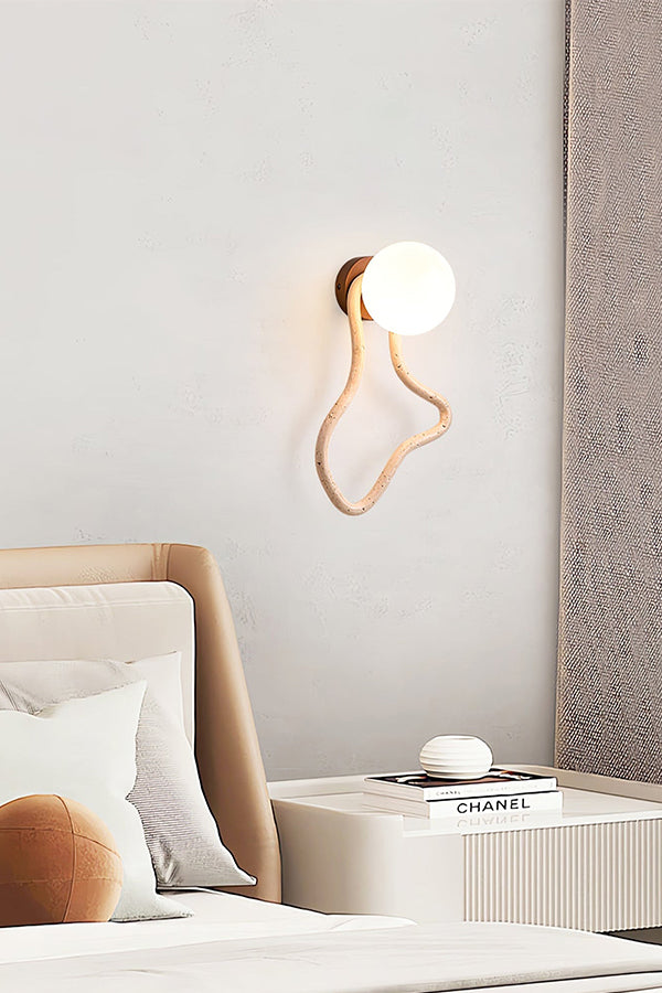 Organic shape travertine wall light in a modern bedroom | Travertine, Glass, Wood | Mounted next to a bed with neutral tones | Samu Lamp