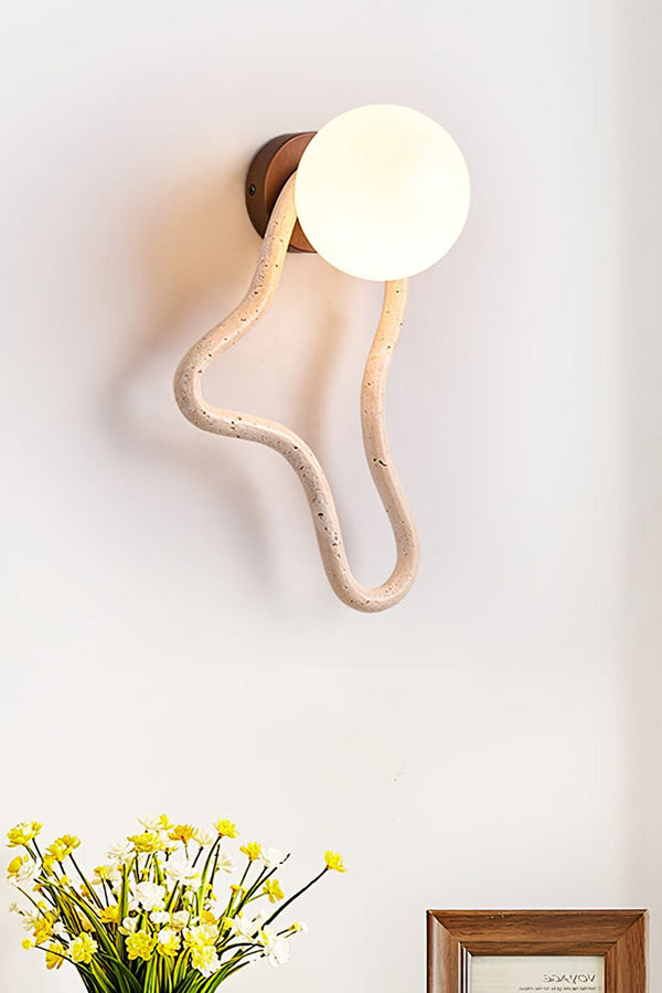 Lit travertine flow sconce with vertical orientation | Travertine, Glass, Wood | Detailed shot above a floral arrangement | Samu Lamp