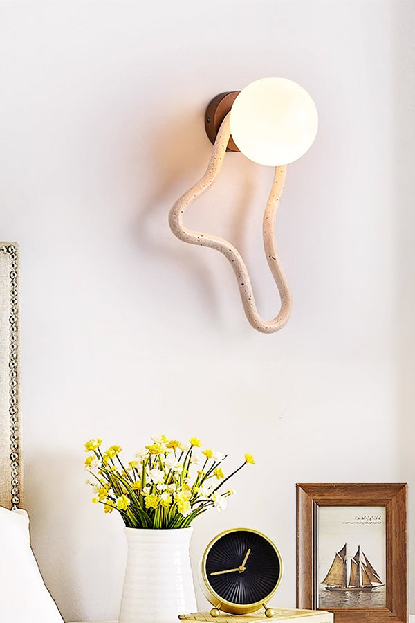 Travertine flow wall sconce in a decorated corner | Travertine, Glass, Wood | Near a vase of flowers and a vintage clock | Samu Lamp
