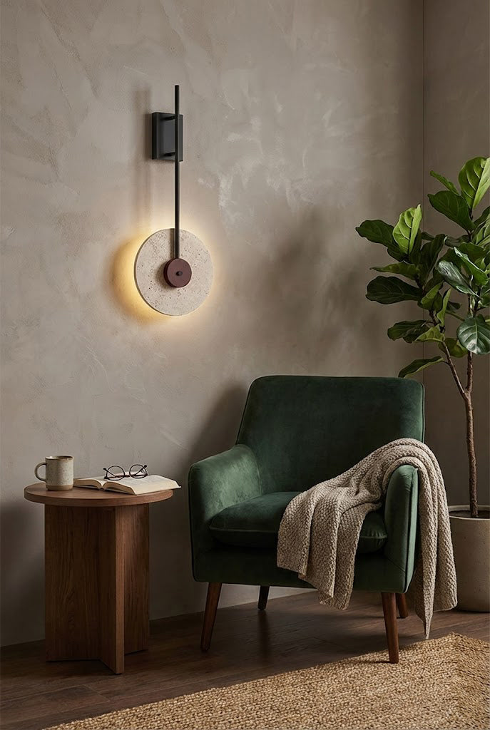 Modern travertine disc wall lamp providing backlighting | Travertine, Wood, Metal | Next to a green armchair in a minimalist lounge | Samu Lamp