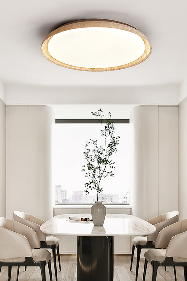 Travertine flush mount light in a minimalist dining area | Wood, Travertine, Acrylic | Above a white dining table with a potted plant | Samu Lamp
