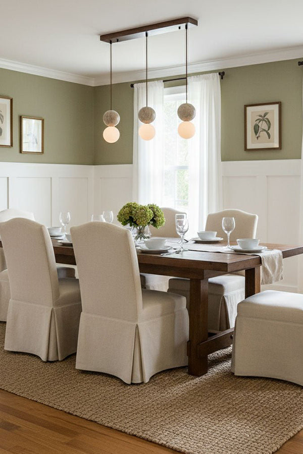 Linear travertine pendant light over dining table | Yellow Travertine, Glass | Installed in a formal dining room with slipcovered chairs | Samu Lamp