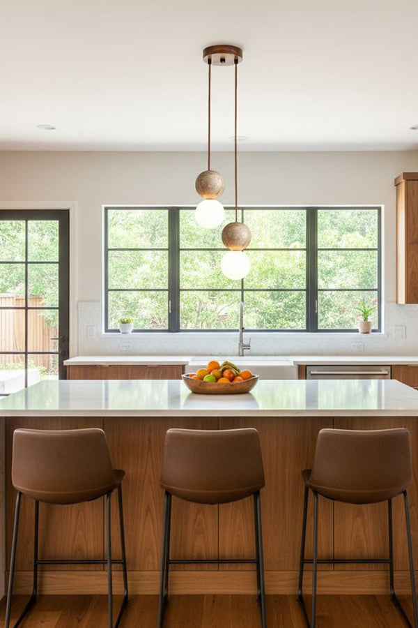 2-light linear stone pendant over kitchen counter | Yellow Travertine, Glass | Modern kitchen interior with brown leather stools | Samu Lamp