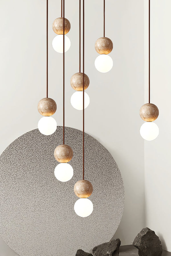 Cluster of travertine and glass pendant lights | Yellow Travertine, Glass | Detailed shot against a grey artistic backdrop | Samu Lamp