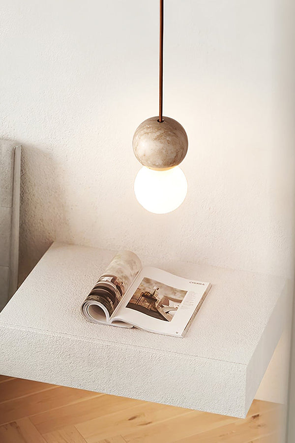 Single travertine pendant over a textured pedestal | Yellow Travertine, Glass | Minimalist interior scene with natural stone | Samu Lamp